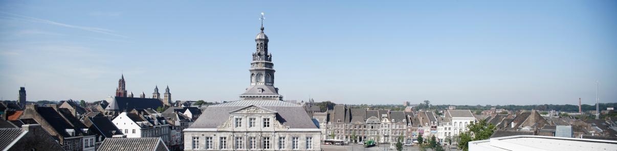 Vergezicht van het Stadhuis en de Markt in Maastricht bij een blauwe lucht